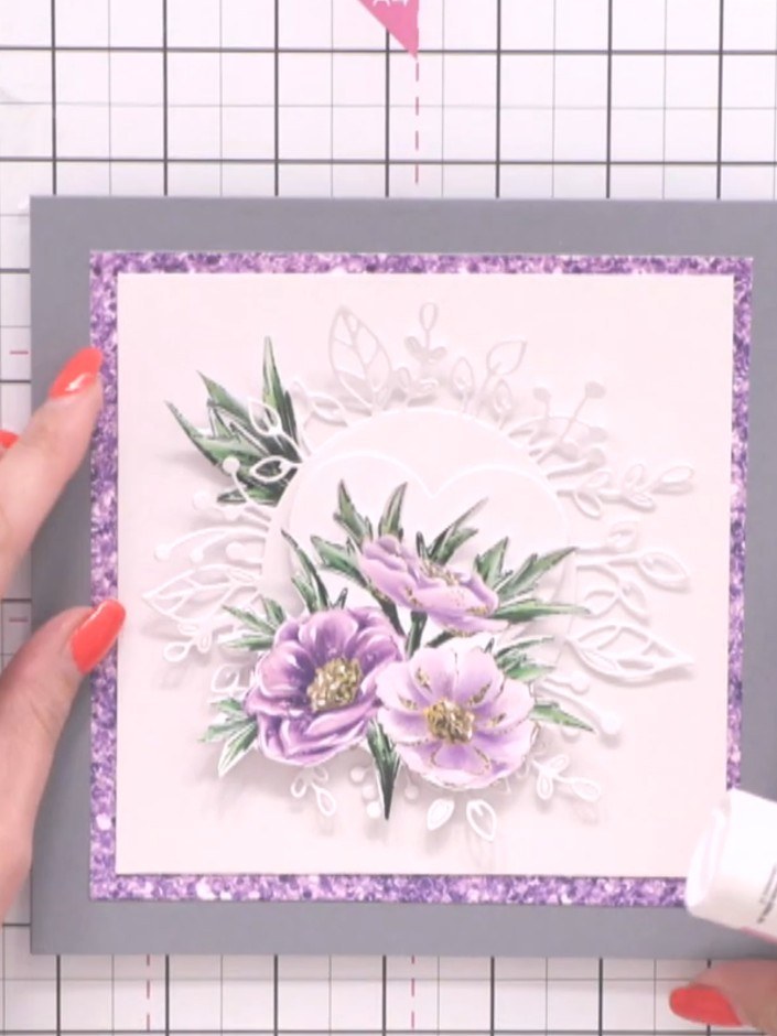 Step 8: Position three fussy-cut green leaf embellishments asymmetrically around the white space on the card front. Us