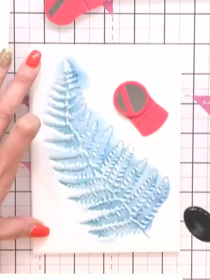 Step 1: Place the fern stencil onto your white card stock. Secure it in position using a glass mat or grip mat to prev
