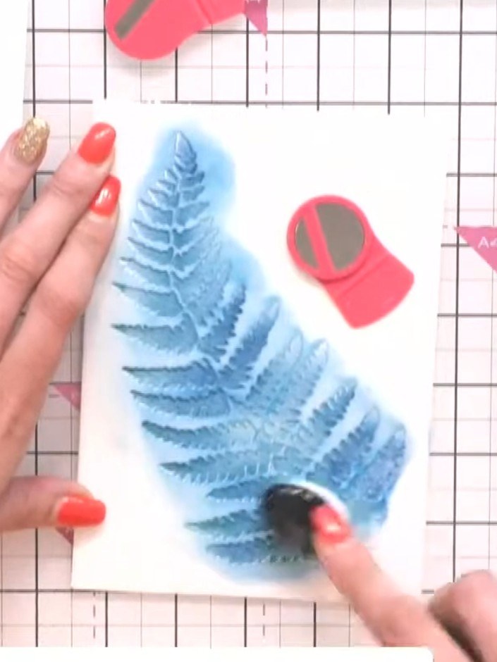 Step 3: Carefully lift away the fern stencil to reveal the blue stamped design underneath. Set the stencil aside for l