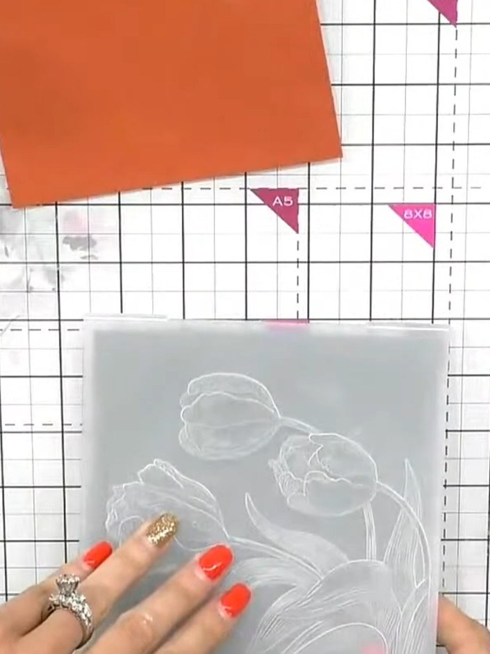 Step 2: Run your purple card blank through the embossing machine with the tulip embossing folder to create a raised de