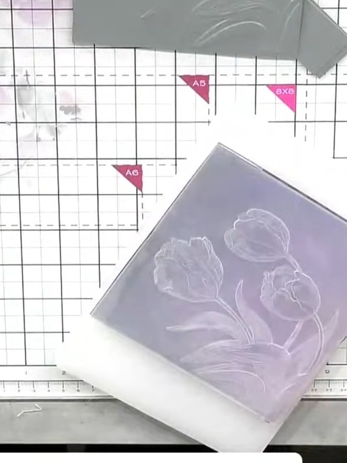 Step 8: Layer the embossed vellum piece onto the embossed card base, carefully matching up the tulip designs. Use a ta