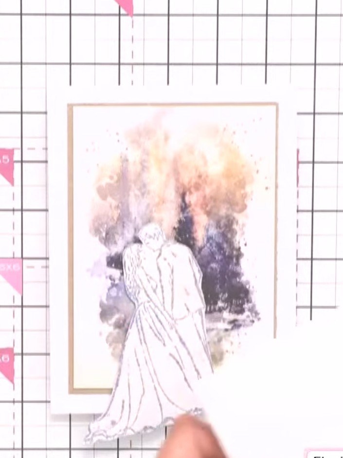 Step 2: Position the embossed bride and groom silhouette in the centre of the painted watercolour mount. Adhere it in 