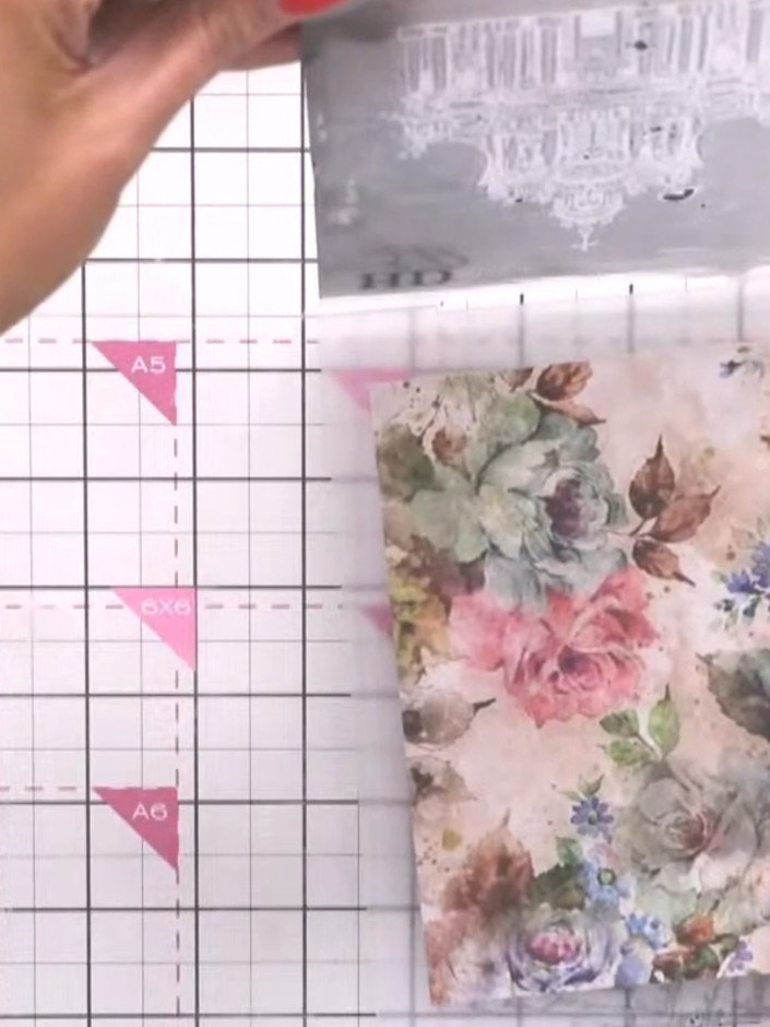 Step 3: Place the pre-printed painted mount with the floral design into the embossing folder. Position it carefully to