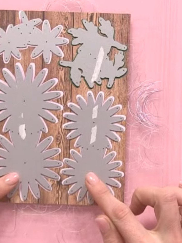 Step 4: Position the die plate with the chrysanthemum flower shapes onto your chosen cardstock. Secure the die plate f