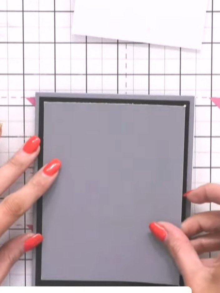 Step 7: Mount the fussy-cut grey Jasper figure onto the black card frame using foam pads to create dimension. Position