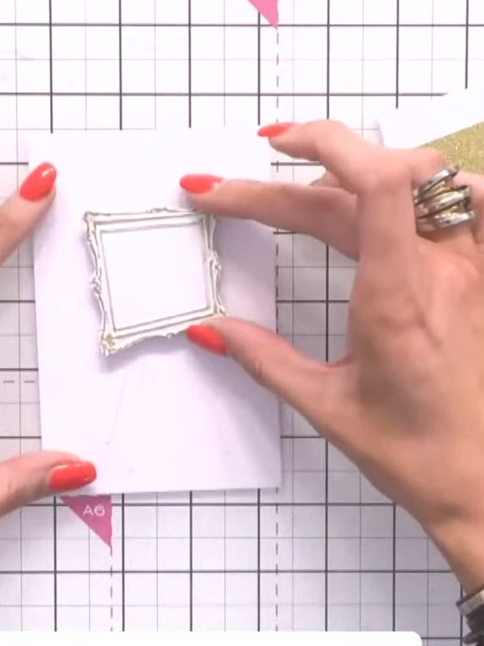 Step 5: Position the white embossed frame piece onto the white card panel. Place the gold glitter cardstock behind to 