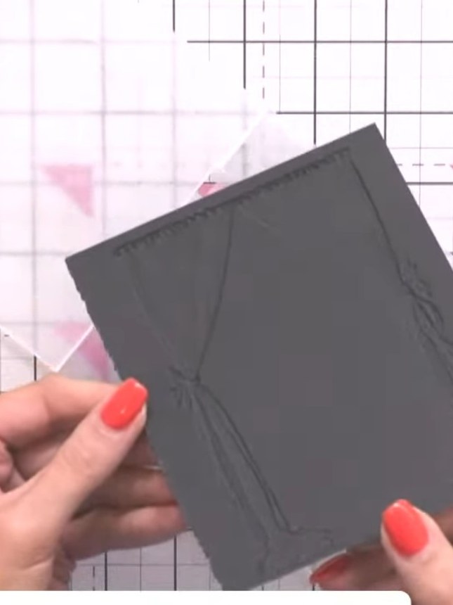 Step 3: Open the embossing folder to reveal the embossed design on the black card. Note that the embossed pattern may 