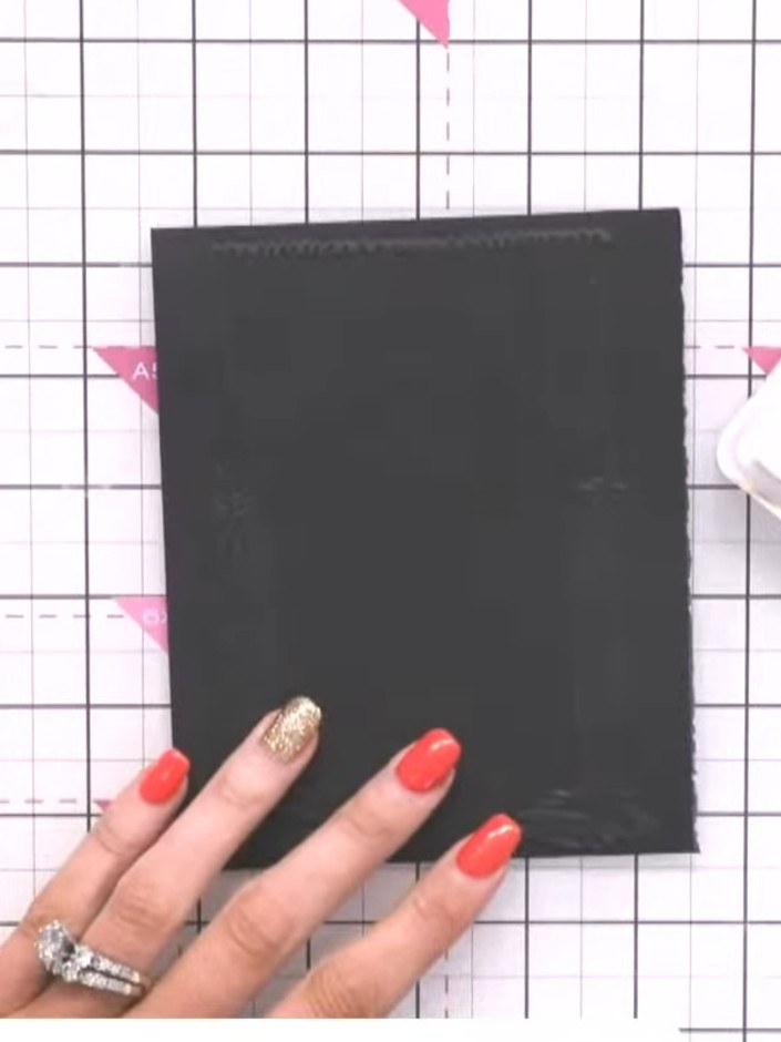 Step 4: Take a white ink pad and tap or swipe it across the embossed design on the black card to bring out the raised 