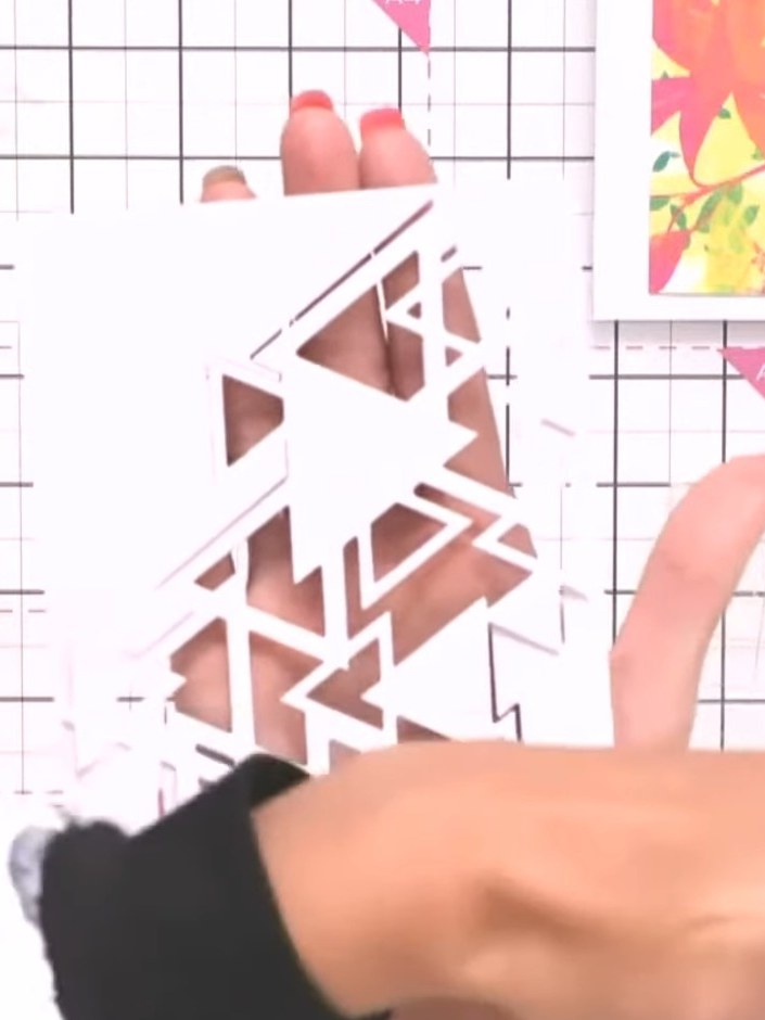 Step 5: Position the coloured card stock (with the triangular die-cut pattern) over the white card blank, aligning it 