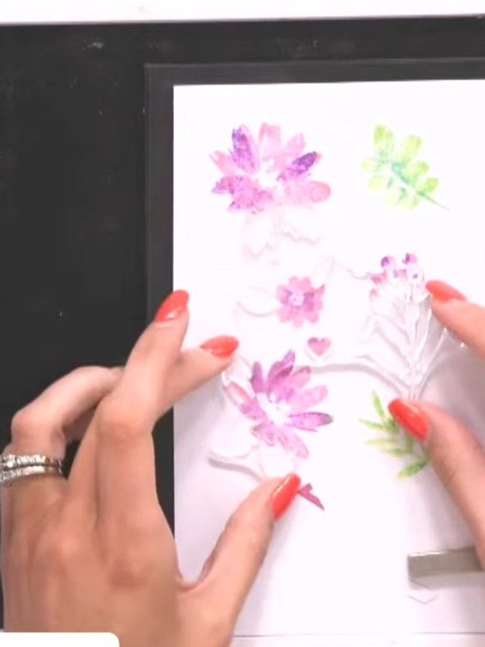 Step 7: Ink the flower stamps with purple ink and the leaf stamps with green ink. Stamp them onto the card in the same