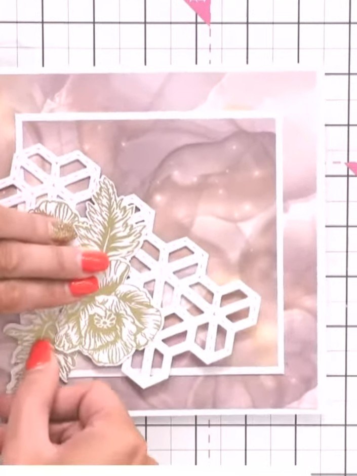 Step 8: Position the gold-embossed poppy flowers onto the white Hexi Mosaic cover plate background. Experiment with th