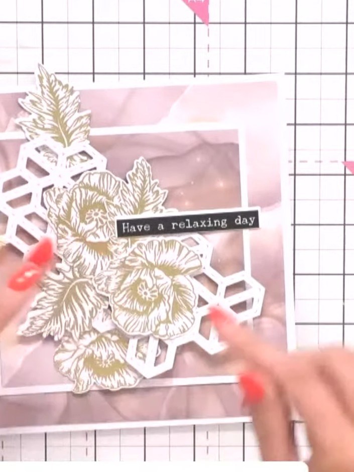 Step 9: Add gold foliage elements from the die-cut pieces around the flowers to frame them. Position the leaves to com