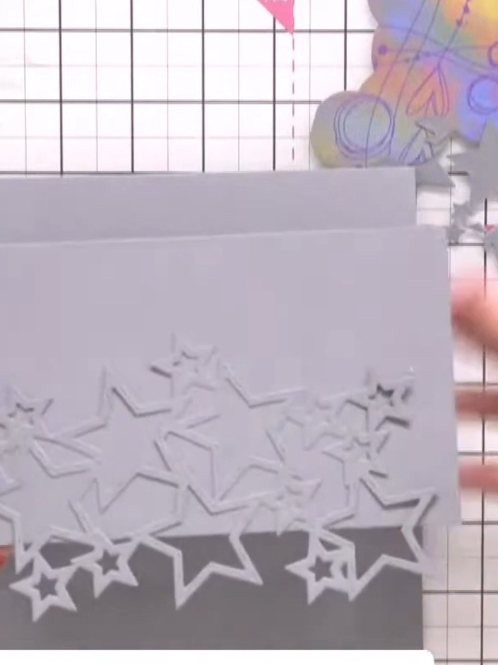 Step 7: Add decorative embellishments to the top of your card. Position die-cut stars and other elements across the up