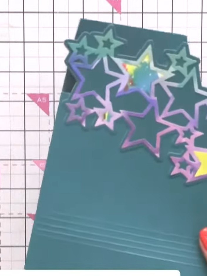 Step 7: Position the star die-cut at an angle across the top of the card to create movement. Secure in place with tape