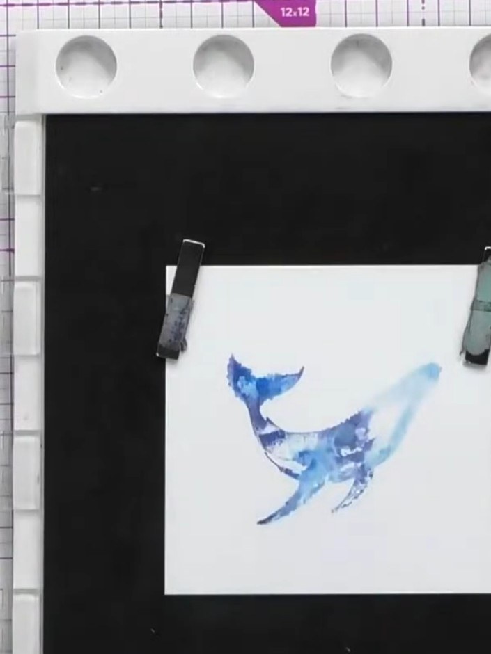 Step 5: Stamp the detailed whale stamp in black ink over the dried watercolour whale to add fine detail and definition