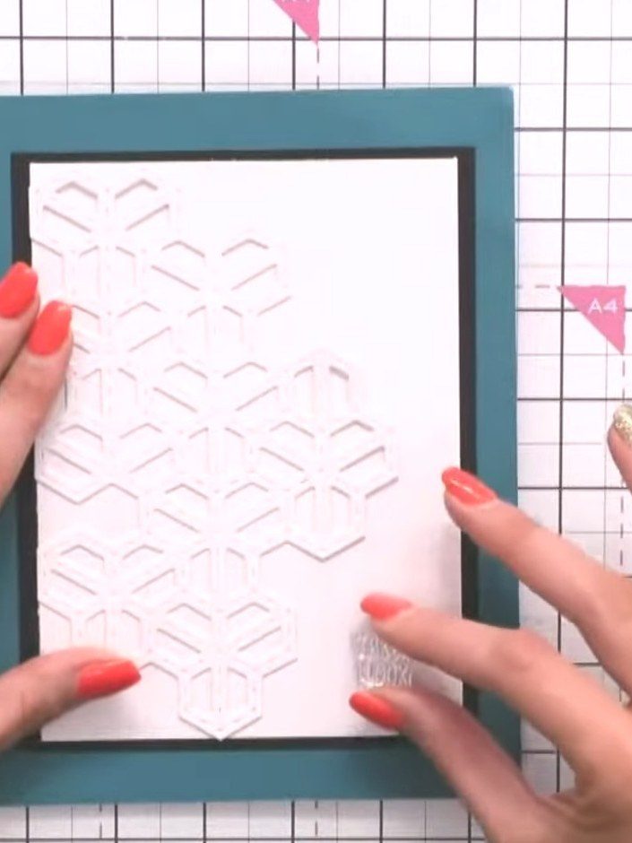 Step 4: Mount the white chevron embossed panel onto the black mat layer, positioning it centrally within the frame. Th