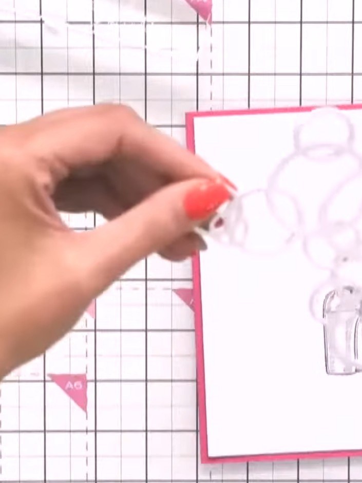 Step 5: Take the die-cut piece with the camera design and carefully position it over the bubble shapes on your card fr
