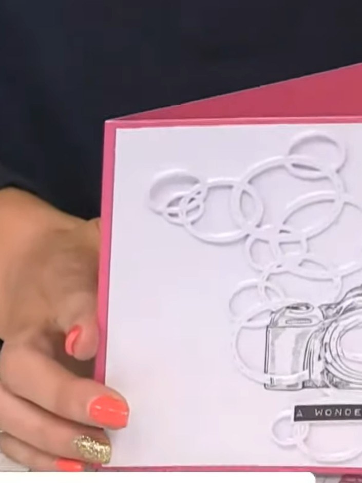 Step 8: Tilt the card to the side to reveal the illusion effect where the bubbles appear to frame the camera design. T