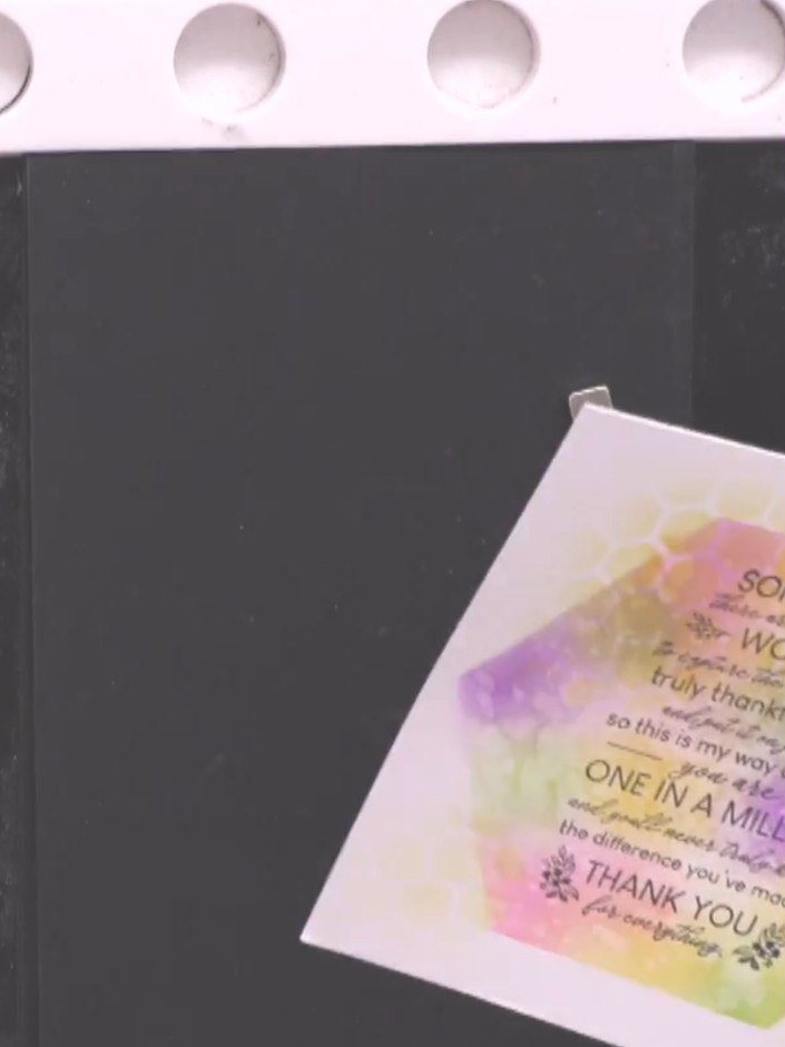 Step 10: Layer the white hexagonal card piece with the stamped sentiment onto the black matted card base. Position it i