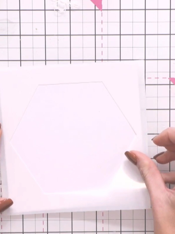 Step 2: Lege die Sechseck-Schablone auf den weißen Cardstock und richte sie so mittig wie möglich auf der Karte aus.