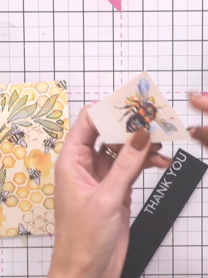 Step 10: Fussy-cut a bee from the patterned paper, cutting loosely around the shape without worrying about perfect prec