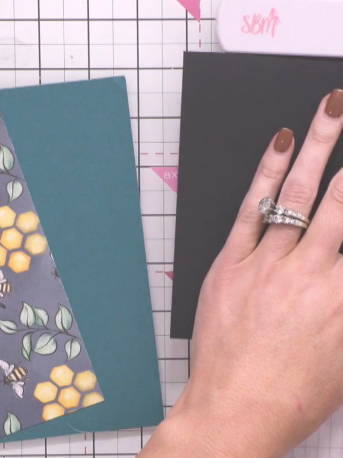 Step 2: Schneide ein Stück schwarzen Cardstock als Mattierungsebene für dein Motivpanel zu. This will frame the bee-patterned