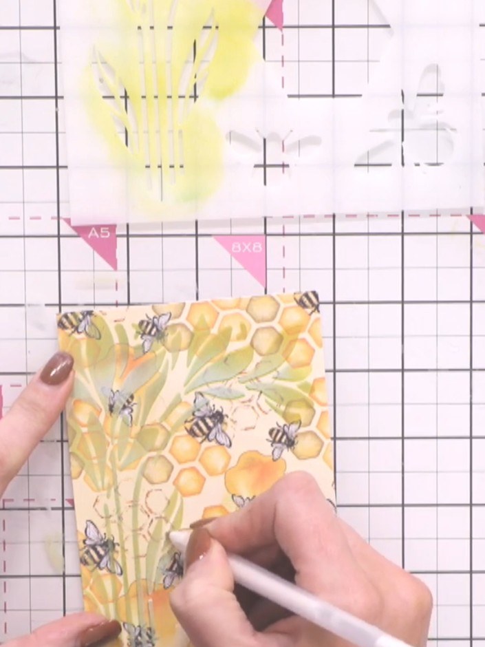 Step 8: Use a black gel pen to outline selected areas of the flower design, working carefully within the stencil lines