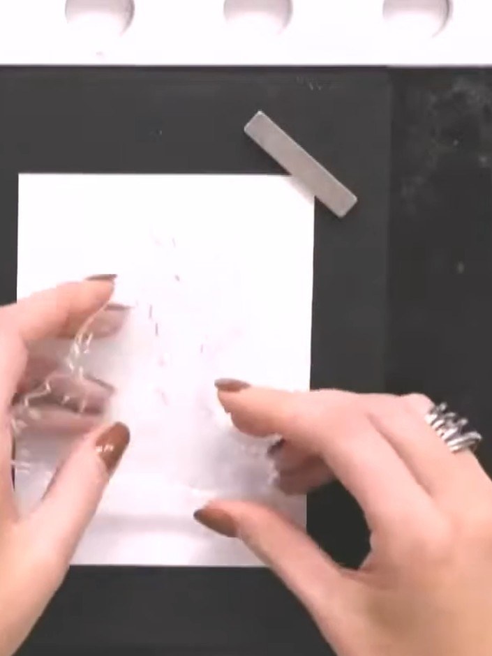 Step 2: Place your white card stock into the inked embossing folder, ensuring it is positioned centrally. Close the fo