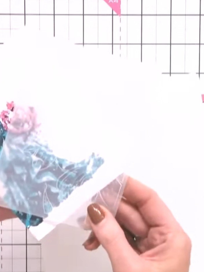 Step 5: Position the sparkled gown figure inside the embossed frame, placing it centrally within the decorative border