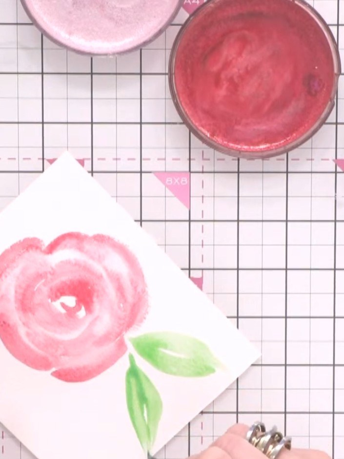 Step 7: Using green ink and the toe-belly-toe technique, paint two large leaves at the base of the flower. Start with 