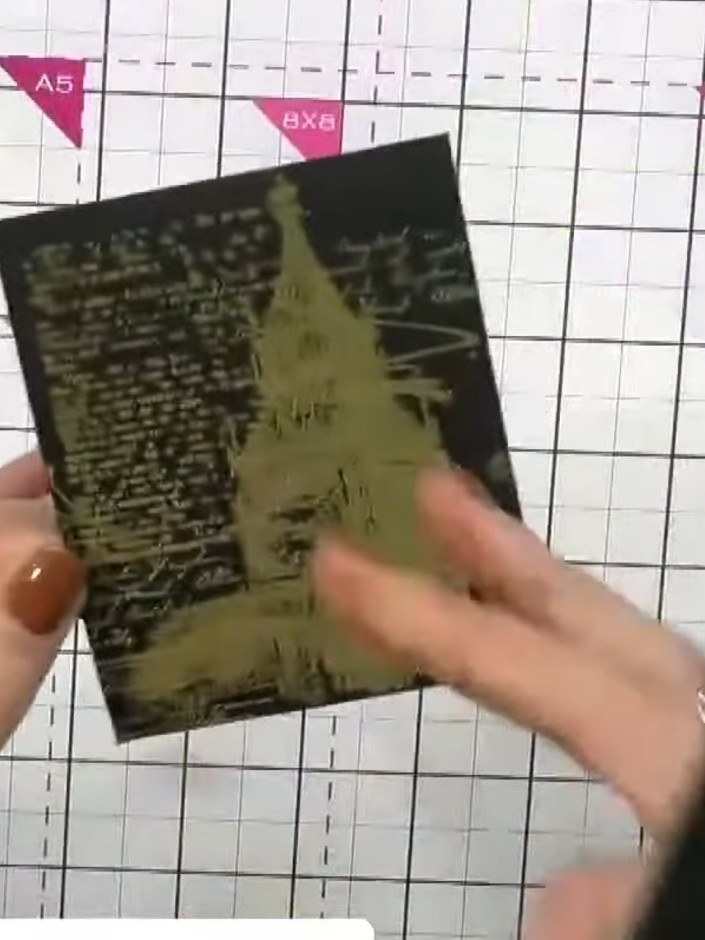Step 5: Sprinkle gold embossing powder generously over the stamped image on the black card. Ensure the powder covers a