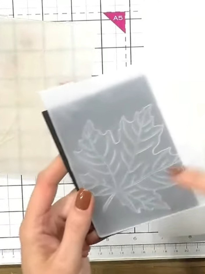 Step 4: Nimm das Papier aus dem Prägefolder und schau dir die erhabenen Details des Baummotivs an.