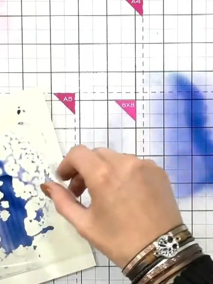 Step 3: Use an acrylic block inked with blue colour and sprayed with water to add texture and pattern to the backgroun