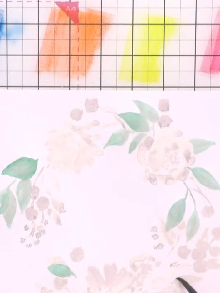 Step 5: Add yellow and orange tones to the flower buds around the wreath. Drop the colour whilst the paper is still we