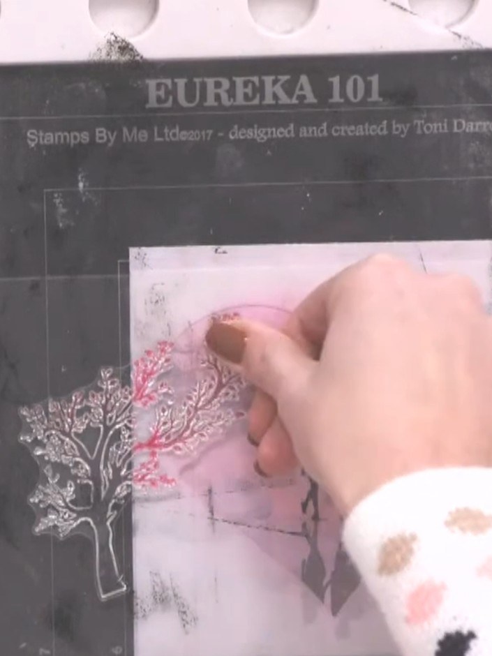 Step 6: Stamp the tree design again in black ink, positioning it slightly offset from the pink stamped tree to create 