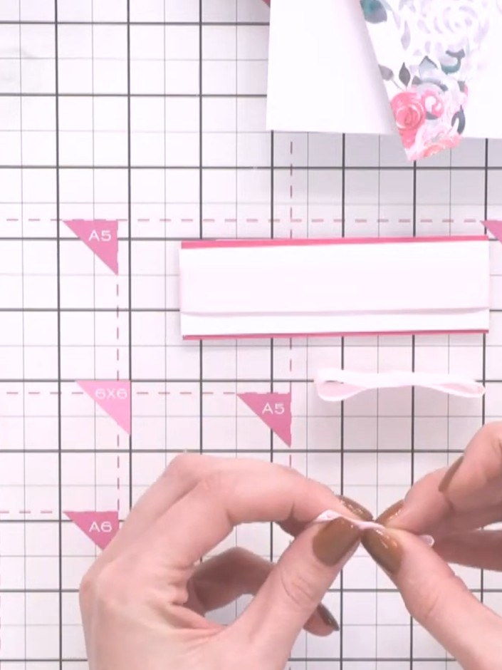 Step 6: Wrap a thin strip of ribbon around the middle of the layered bow loops. Secure the ribbon at the back with glu