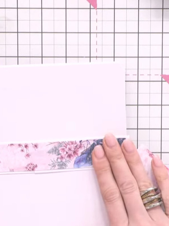 Step 10: Adhere the patterned paper strip to the back cover of the album. Embellish the belly band by attaching a fussy