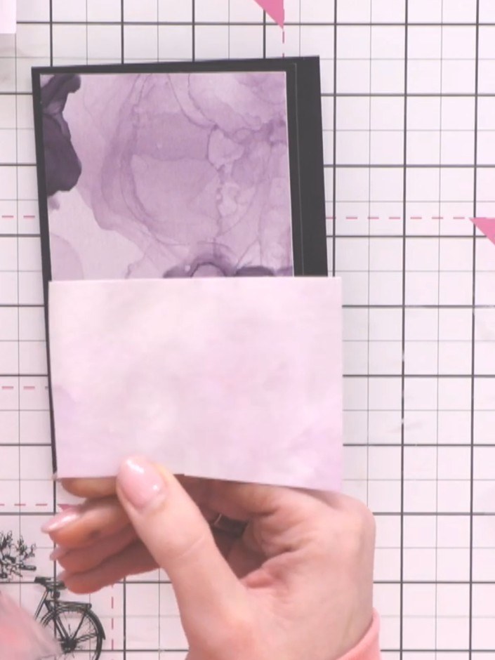 Step 1: Such dir aus dem Papierblock ein Stück Cardstock in Lilatönen als Kartenbasis aus.