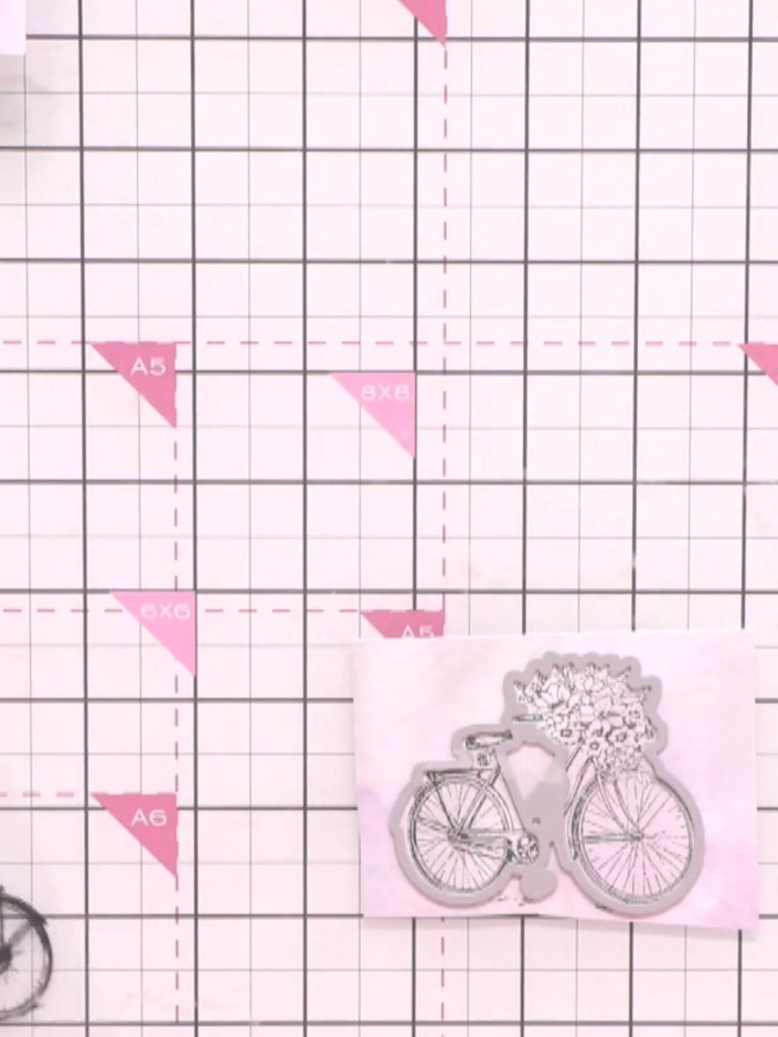 Step 3: Position your stamped bicycle images on the cutting mat. Secure them in place with low-tack tape, then place t