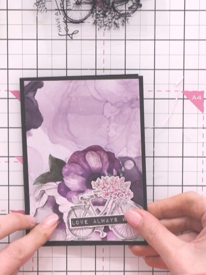 Step 9: Trim a sentiment banner from the stamp set and adhere it across the bicycle using glue to complete your mini c