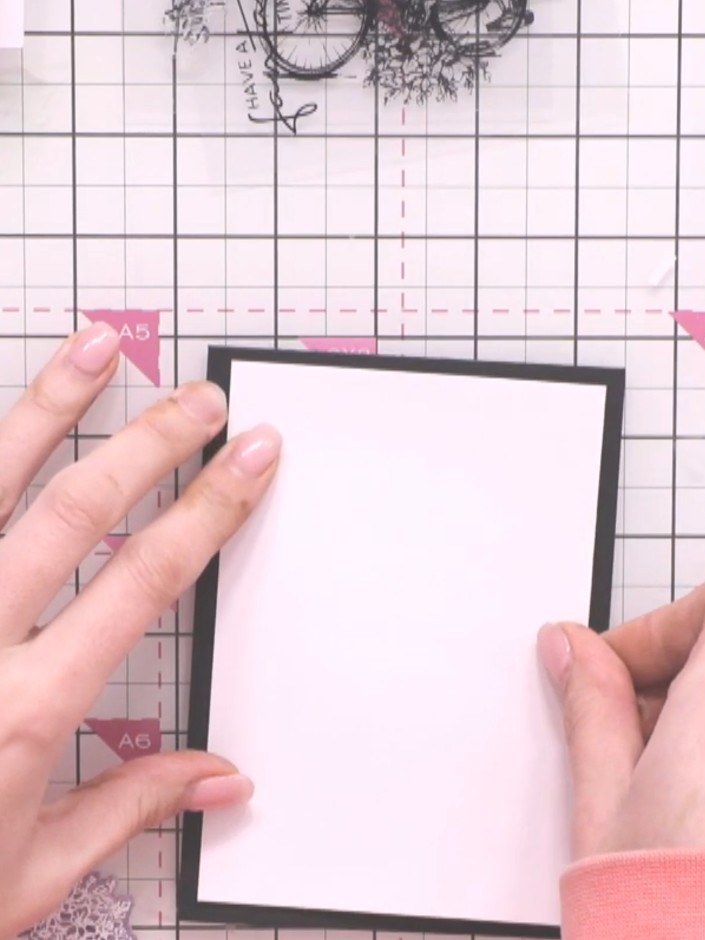 Step 10: Glue the patterned paper piece with the door design onto the white card layer, positioning it centrally within