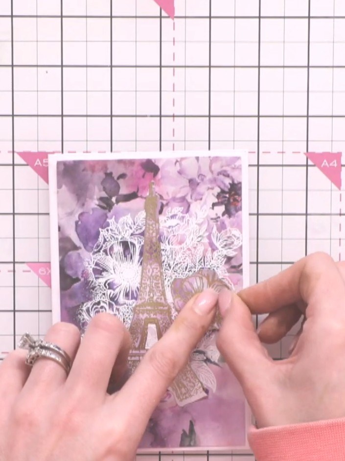 Step 11: Attach the white die-cut flower pieces to the card using small amounts of glue. Gently pinch and cinch the end
