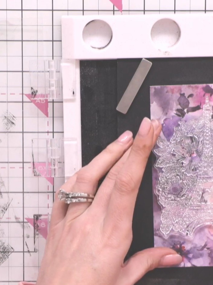 Step 2: Prepare your black card base with the patterned paper. Use an antistatic bag on the paper, then stamp the Eiff