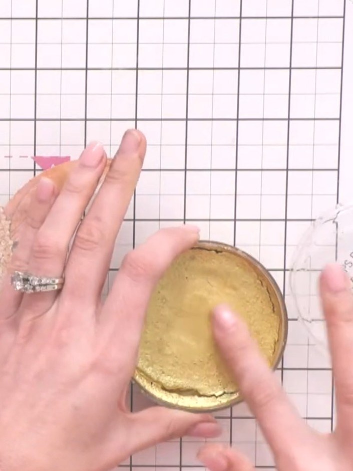 Step 13: Add a touch of gold confetti ink to the centre of the flower using your finger or an applicator to catch the l