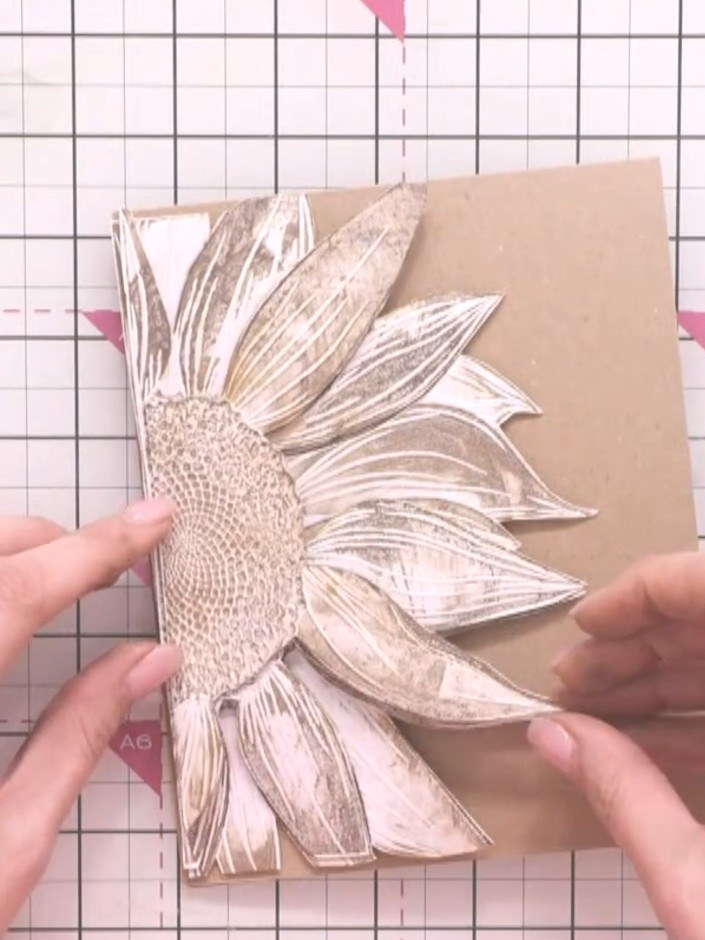 Step 16: Layer the three painted and cut sunflower pieces together using foam pads or adhesive. Start with the base lay