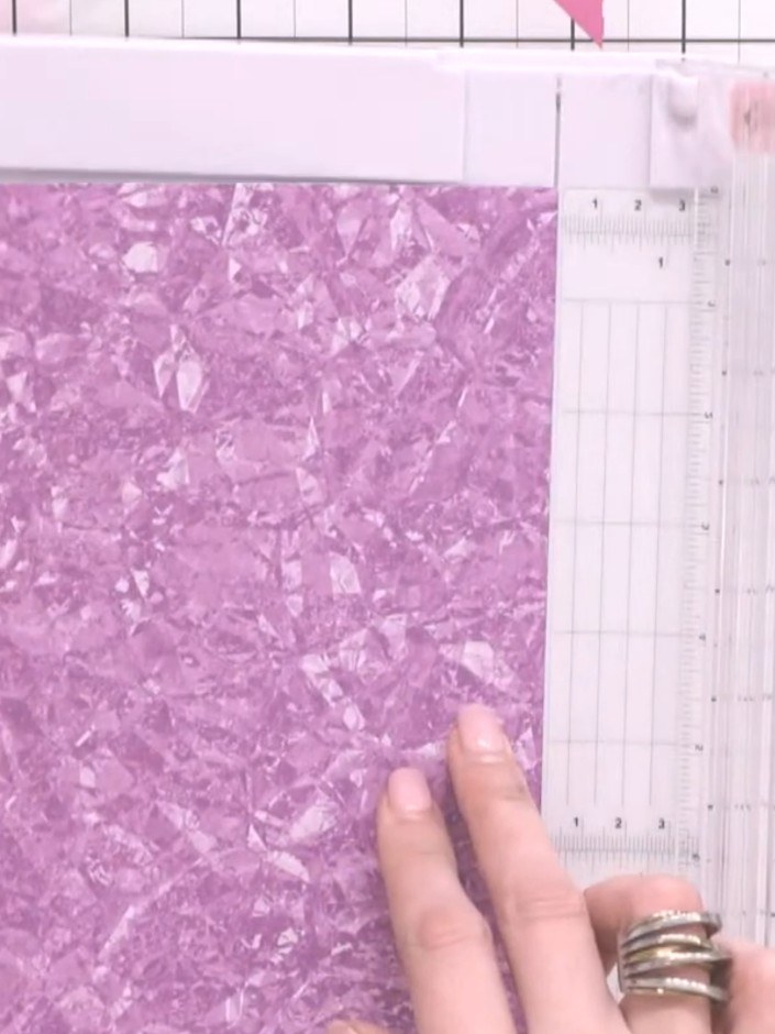 Step 1: Cut a piece of purple patterned paper from 8 by 8 inches down to 6 by 8 inches using a guillotine or paper tri