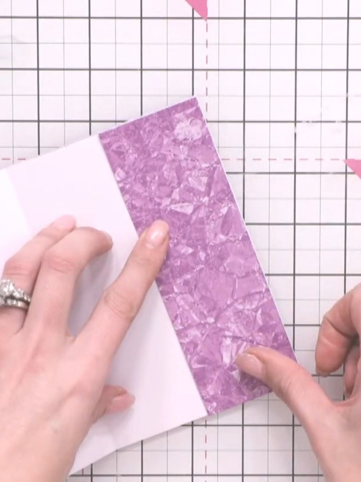Step 5: Fold the opposite edge of the purple textured paper back and glue it to the white card to create a second pock