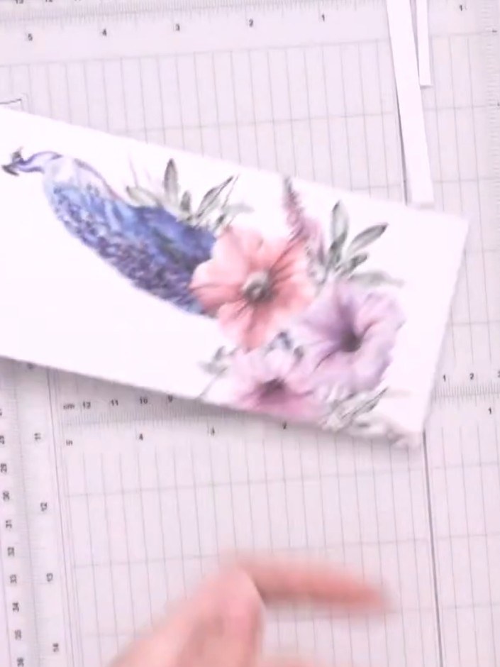 Step 8: Trim additional pieces from the leftover peacock and floral paper to create embellishments. Cut off the top po