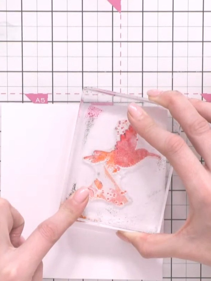 Step 3: Spritz the stamp with water and press it onto the white card to create the first bird image. Position the bird