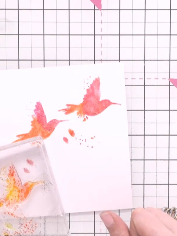 Step 5: Ink the stamp with orange and yellow ink, spray with water, and stamp a third bird in the lower portion of the
